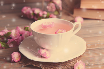 Cup of tea and beautiful fruit blossom on table