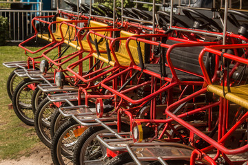 A row of surrey bikes at the beach. 