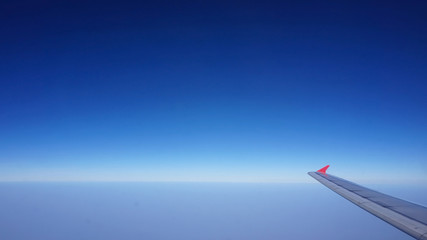 plane wing with blue horizontal skyline with no cloud