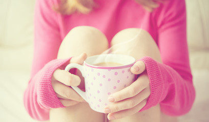 cup of hot coffee warming in the hands of a girl