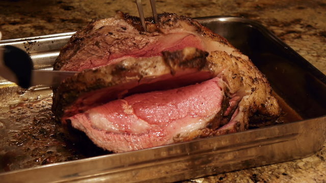 Prime Rib Roast Being Cut With Electric Knife.