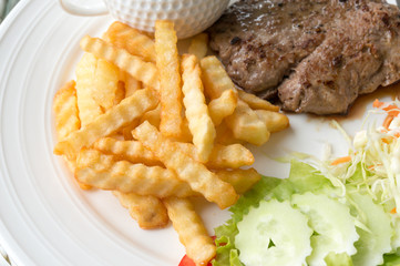 French Fries and pork steak, selective focus at French Fries
