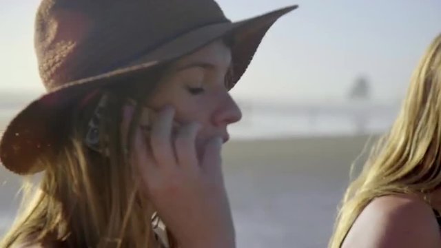 Attractive teenage girl uses her cell phone at the beach 