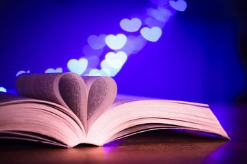 Book with low light and blue bokeh in heart shaped