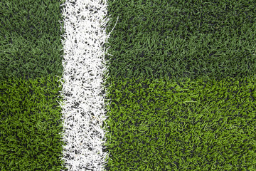 Obraz premium Photo of a green synthetic grass sports field with white line sh