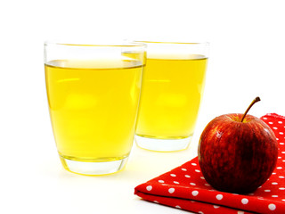 red apples and glass of fresh apple juice over white background