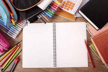 Busy student desk in college or school with blank open notebook pencils and equipment studying homework photo with space for copy text
