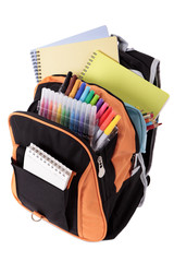 School bag backpack with various books pencils crayons and study equipment isolated on white...