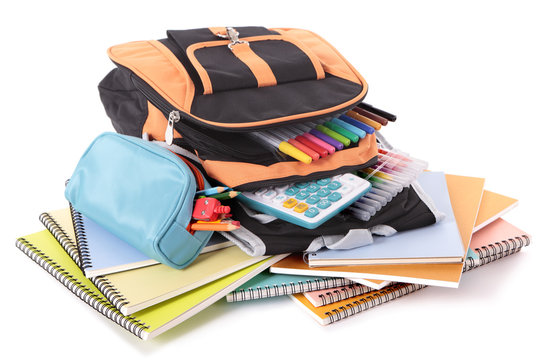 School bag backpack with various books pencils crayons pencil case and study equipment isolated on white background photo