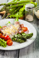 Baked green asparagus with prosciutto and cheese