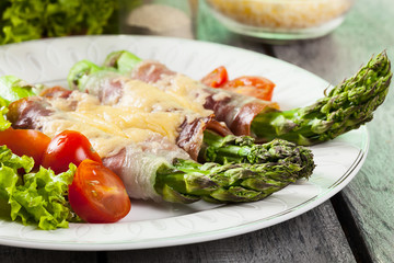 Baked green asparagus with prosciutto and cheese