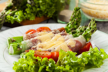 Baked green asparagus with prosciutto and cheese
