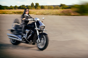 Fototapeta na wymiar Biker girl in leather jacket riding on a motorcycle.