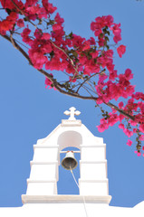 Church Bell and pink flowers in Mykonos, Greece