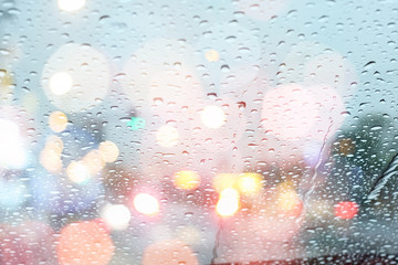 Rain drops on car window with light bokeh, rainy season abstract