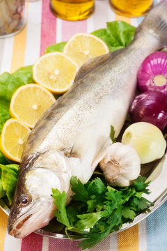 Close Up Of Walleye Fish With Lemon Slices And Onion Served On Plate