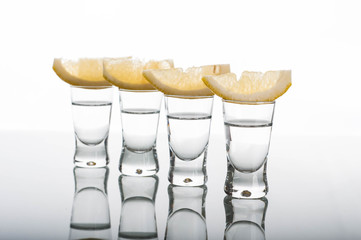 Four shots of vodka with lemon