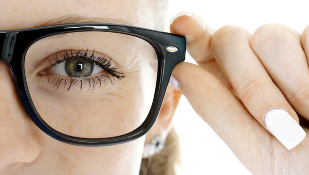 Frau setzt Brille als Sehhilfe von Optiker auf
