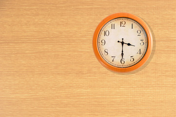 Clock showing 3:30 o'clock on a wooden wall