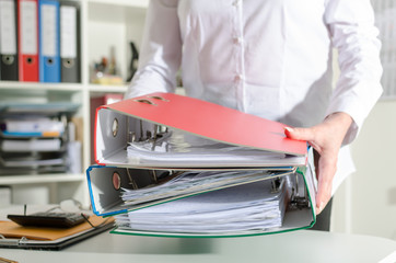 Businesswoman holding binders