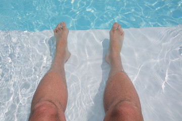 Man's feet on the background of a swimming pool.