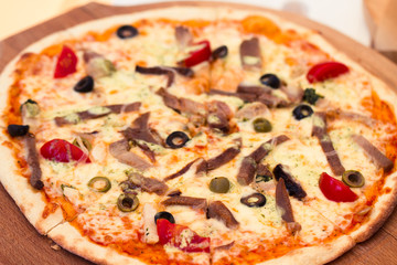 Pizza with meat, tomatoes and olives
