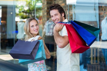 Rear view of couple with shopping bags