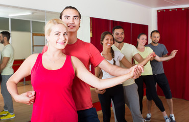 Group of people dancing salsa in studio