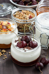 dessert with cream and jam in glass jar on dark wooden table