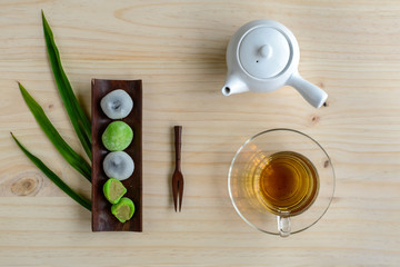 Daifuku green tea and sesame filling with cup of tea on wooden ta