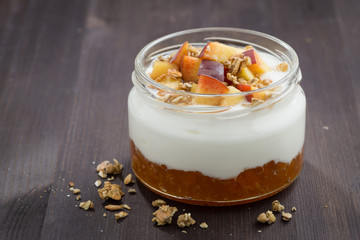 dessert with cream, granola and peach jam, closeup