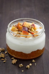 dessert with cream, granola and peach jam, vertical, closeup