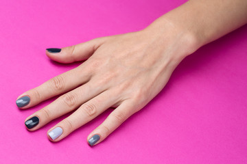 Delicate female hand with a stylish neutral manicure