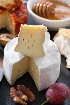 molded cheeses and snacks on the blackboard, vertical, close-up