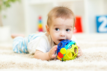 baby lying on soft carpet in children room