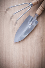 Steel gardening trowel fork with shovel on wooden board agricult