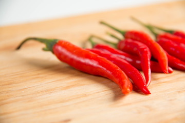   fresh raw red hot chili peppers on wood