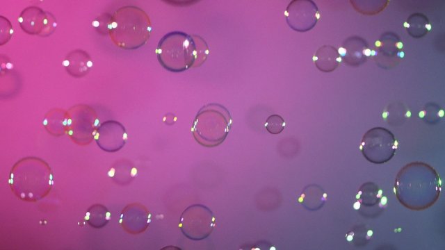 Blue and clear soap bubbles on pink and violet, background