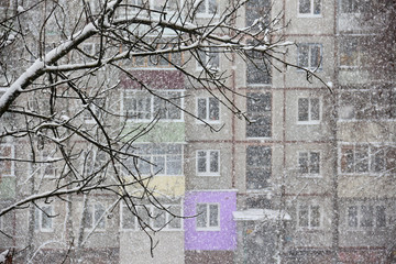 Heavy snowfall opposite windows of residential house