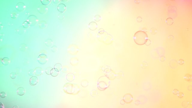 Blue and clear soap bubbles on turquoise and pink, background