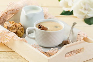 Morning coffee with cinnamon and milk in cream jug