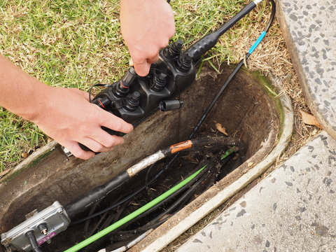 Installation of a customer connection drop cable plugging in a 8 port Multiport in a road side communications pit used for the installation of the National Broadband Network in Australia 2015