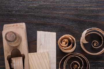 Wooden planer bricks and curled up planing chips on vintage wood