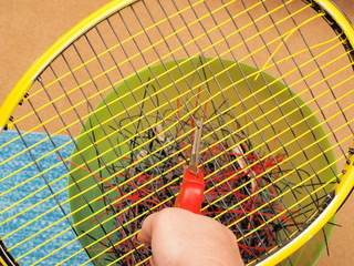 Cutting out old Tennis strings with a cutter in preparation to install new fresh string on a...
