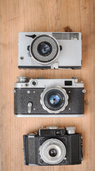three retro cameras on wooden background