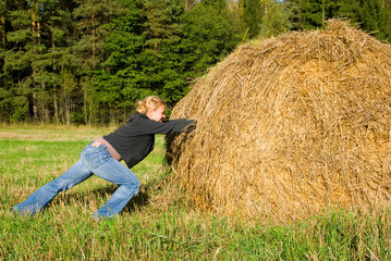 Naklejka na ściany i meble Girl rolling the haystack