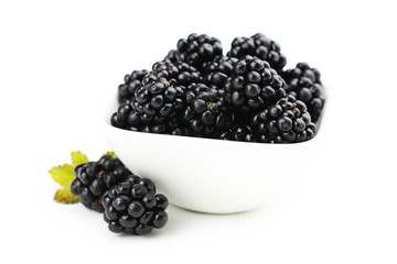 Beautiful ripe blackberry in bowl on white background