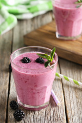 Blackberry smoothie in the glasses on grey wooden background