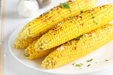 Fresh tasty grilled corn on white plate