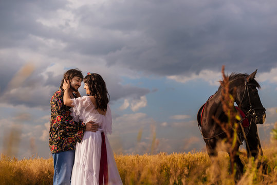 young couple and horses in field